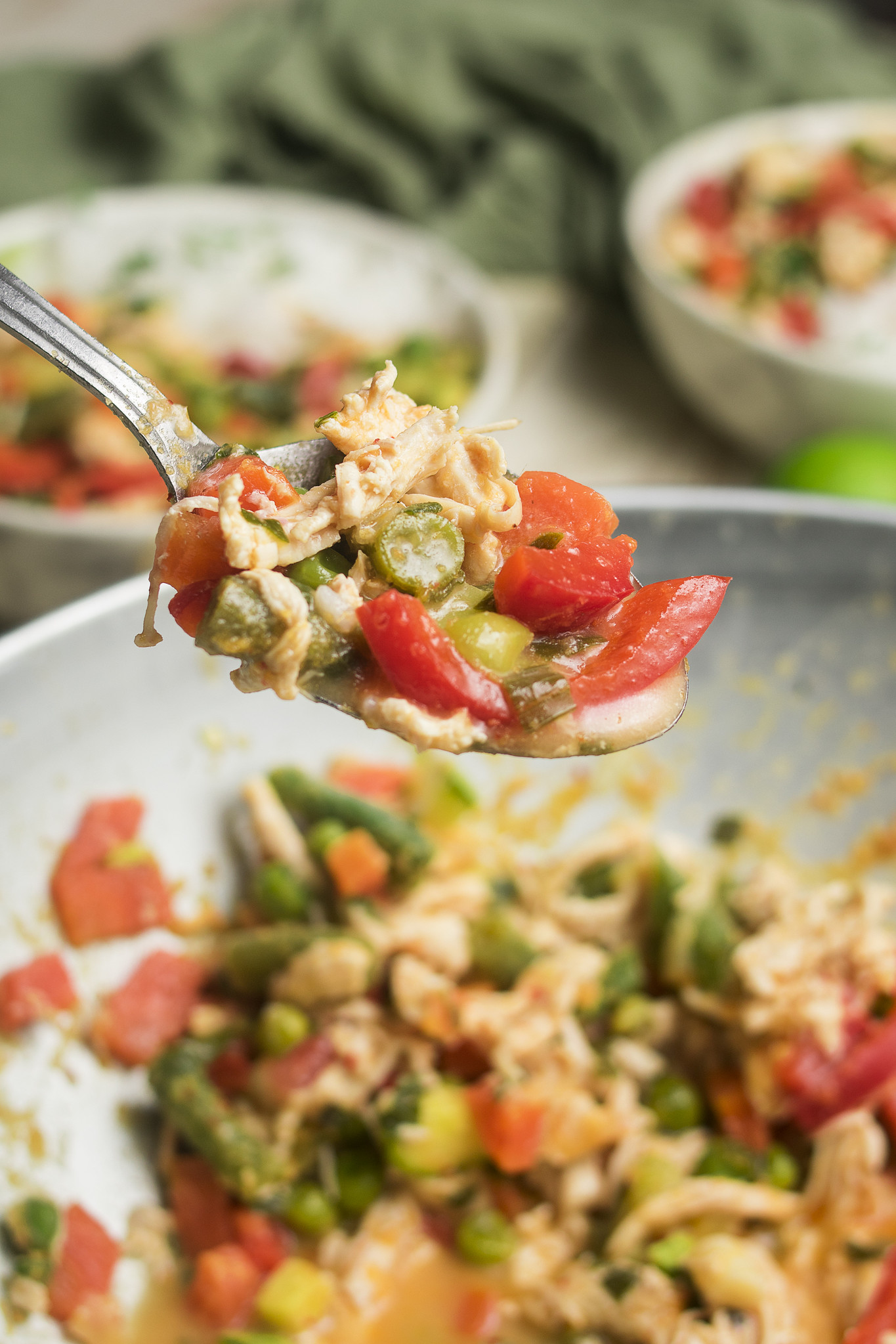 Spoonful of Thai-inspired chicken curry with red pepper, green vegetables and coconut sauce.